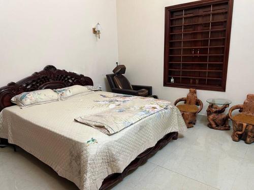 a bedroom with a bed and chairs and a window at Happy Homestay Móng Cái in Móng Cái