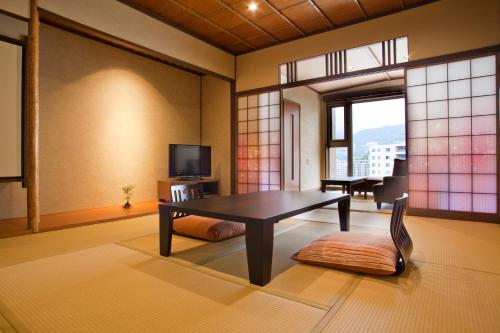 a living room with a table and a chair at Yuyado Ichibanchi in Atami
