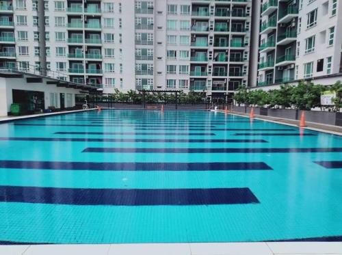 a large swimming pool in front of tall buildings at Kid Slide Family Apartment with 2 Bedroom + 2 Bath in Masai