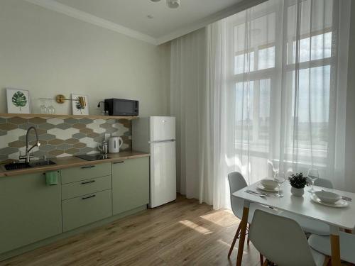 a kitchen with a white refrigerator and a table with chairs at Город Ботанический in Taldykolʼ