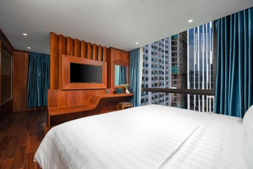 a bedroom with a bed and a television and a window at Monalisa Luxury Hotel in Da Nang