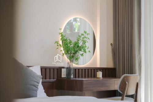 a bedroom with a mirror and a table with a plant at PLEIKU HIGHLANDS BOUTIQUE HOTEL in Plei Brel (2)