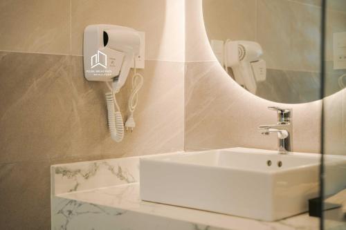 a bathroom with a sink and a phone on the wall at PLEIKU HIGHLANDS BOUTIQUE HOTEL in Plei Brel (2)