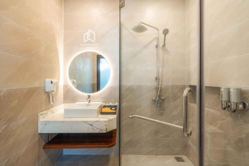 a bathroom with a shower with a sink and a mirror at PLEIKU HIGHLANDS BOUTIQUE HOTEL in Plei Brel (2)