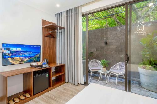 uma sala de estar com televisão e uma grande janela em PLEIKU HIGHLANDS BOUTIQUE HOTEL em Plei Brel (2)