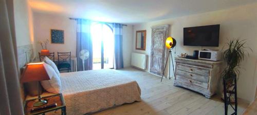 a bedroom with a bed and a television on a dresser at L'Art des Choix in Saint-Jean-de-Pourcharesse