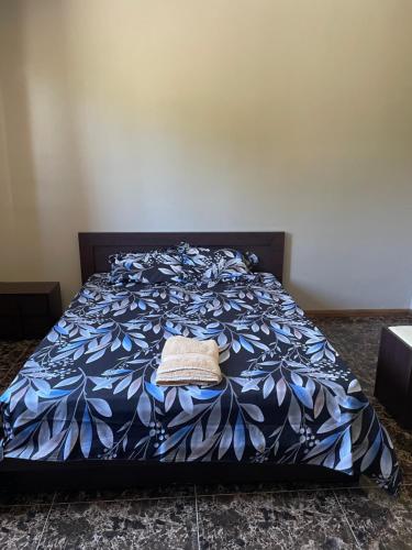 a bed with a blue blanket with a hat on it at Riambel Paradise Inn Primary Apartment in Riambel