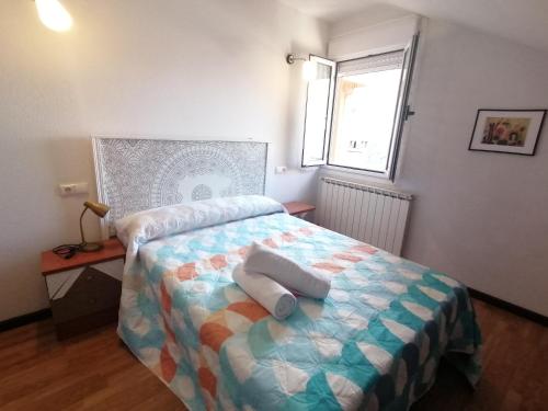 a bedroom with a bed with two pillows on it at Ático 3 hab en centro de Cangas in Cangas de Onís