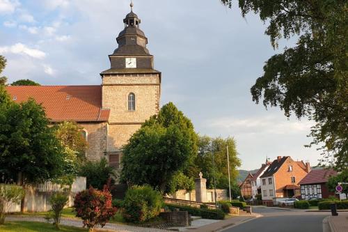 a church with a clock tower on a street at Stilvolle Ferienwohnung im Eichsfeld in Niederorschel