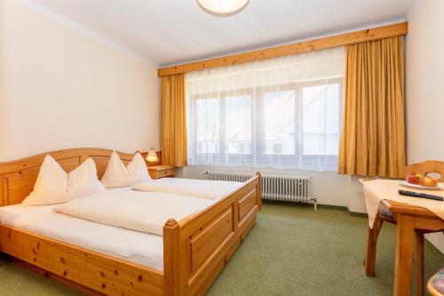 a bedroom with a wooden bed and a window at Der Graggober in Oberwölz Stadt