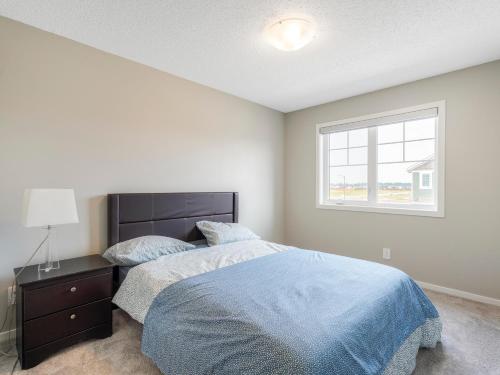 1 dormitorio con cama y ventana en A cozy 3 bedroom new house with 2 living rooms en Edmonton