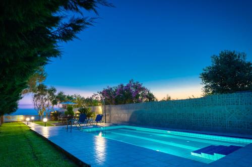 a swimming pool in the backyard of a house at Villa Angela in Ágios Matthaíos