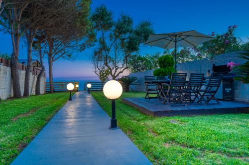 two lights on a sidewalk with a table and chairs at Villa Angela in Ágios Matthaíos