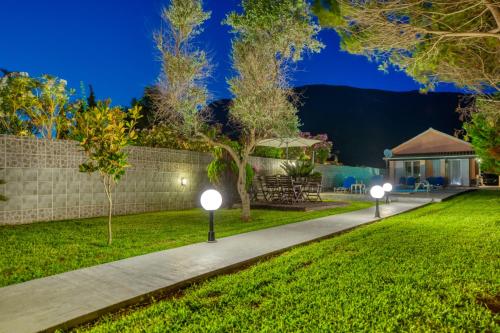 a garden with two lights on the grass at Villa Angela in Ágios Matthaíos
