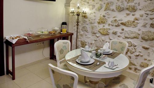 a dining room with a white table and chairs at Antica Dimora Suites in Rethymno Town