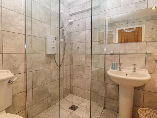een badkamer met een douche en een wastafel bij Victoria House in Rhosneigr