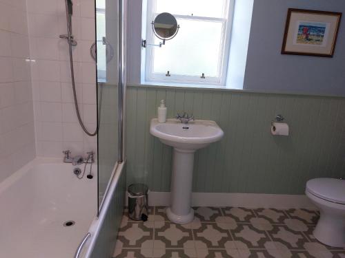ein Bad mit einem Waschbecken, einem WC und einem Fenster in der Unterkunft Upper West Wing Flat - Tarvit in Cupar
