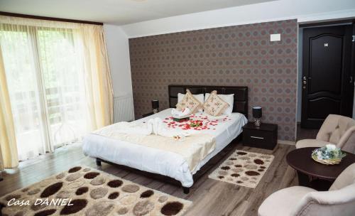 a bedroom with a large bed with red flowers on it at Casa Daniel in Bran