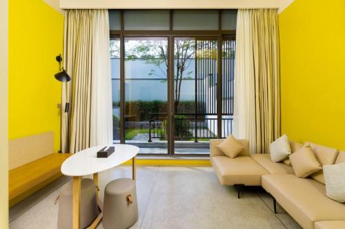 a living room with a couch and a table at SongShan Lake PingShang Serviced Hotel in Huangcaolang