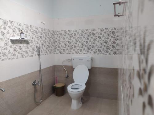 uma casa de banho com um WC e um chuveiro em WoodPacker Hostel Auroville Pondicherry em Auroville