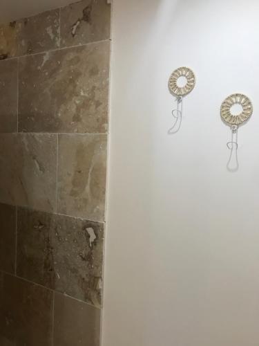 La salle de bains est pourvue d'une douche et d'un ventilateur mural. dans l'établissement Le MAS du Paradis Bleu, à Saint-André-de-Cruzières