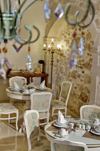 a dining room with tables and chairs and a chandelier at Antica Dimora Suites in Rethymno Town