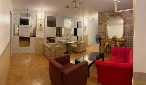 sala de estar con muebles de color rojo y espejo en Jupiter Homestay, en Cabanatúan