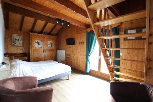 a bedroom with a bed and two chairs at Chalet Gîte Le Titlis in Bernex