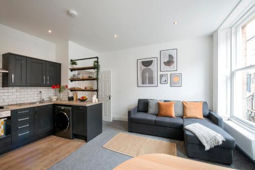 a living room with a couch and a kitchen at Preston Apartments in Preston