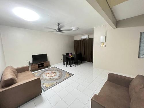 ein Wohnzimmer mit einem Sofa und einem TV in der Unterkunft Netflix Wifi (3 Rooms) Homestay Kak Nad Saujana Utama in Sungai Buloh