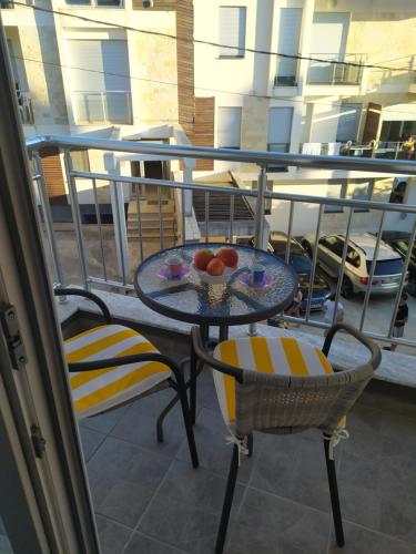 una mesa y sillas con un bol de fruta en el balcón en Apartments Milic-Ulcinj, en Ulcinj