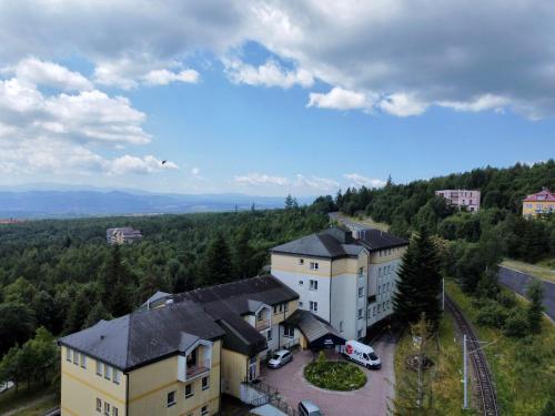 an aerial view of a building with a parking lot at Penzión na vyhliadke in Vysoke Tatry - Horny Smokovec