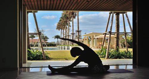 a silhouette of a child sitting in front of a window at The Uza Terrace Beach Club Villas in Yomitan