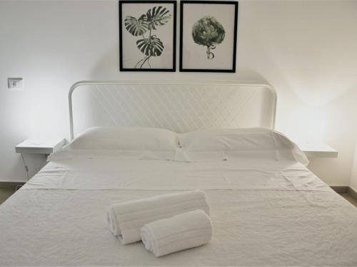 a white bed with two towels on top of it at Dolce Vacanza in Cefalù