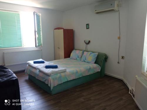 um pequeno quarto com uma cama num quarto em Summer SZ Guest House em Sozopol