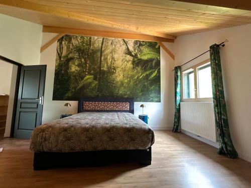 1 dormitorio con 1 cama y una pintura en la pared en les anthocyanes CHAMBRE FORET, en Champagny