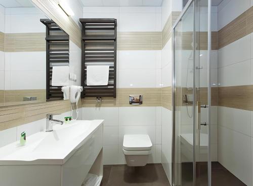 W łazience znajduje się toaleta, umywalka i prysznic. w obiekcie Hotel Tanzanit w mieście Jesionka