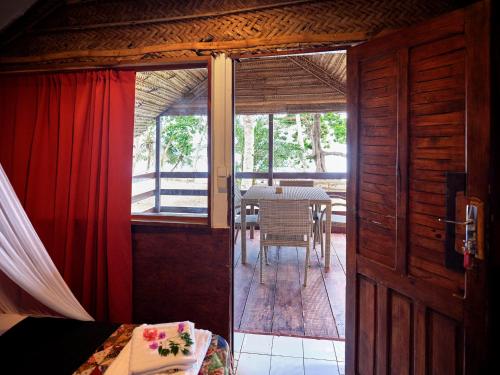 a room with a bed and a table and a door at Le Jardin Maore in Kani Keli