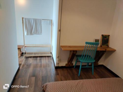 Cette chambre comprend un bureau et une chaise verte. dans l'établissement Căn hộ 2 phòng ngủ, à Ấp Ða Lợi