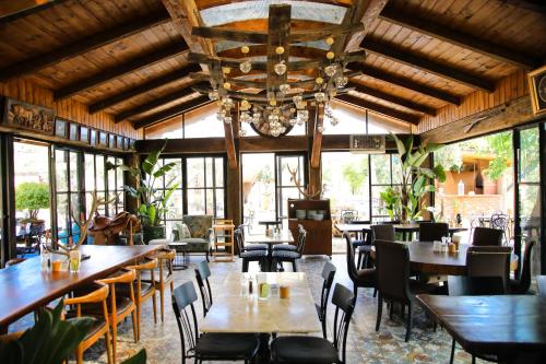 a restaurant with tables and chairs and a chandelier at MAVİ AT HOTEL Blue Horse in Gümüşdere