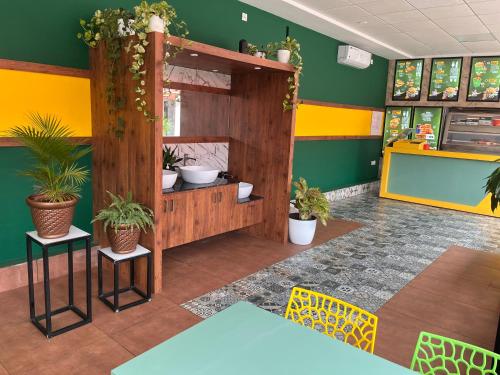 um restaurante com plantas nas paredes e uma mesa em Exit17 em Payyannūr