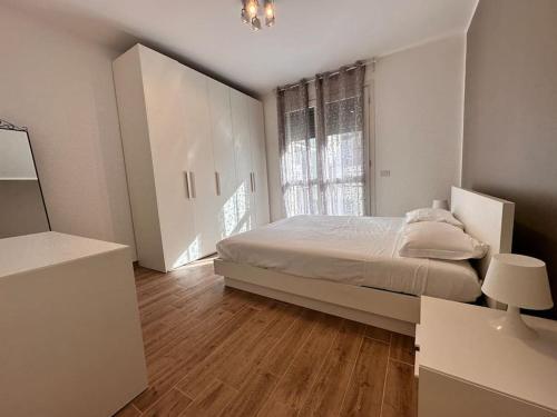 um quarto branco com uma cama e uma janela em NEW Duomo, Hospital, ENI - Cozy Home em San Donato Milanese