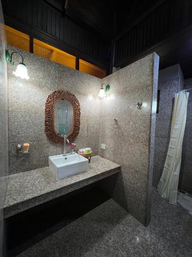 a bathroom with a sink and a mirror at Sasitara Thai Villas in Choeng Mon Beach