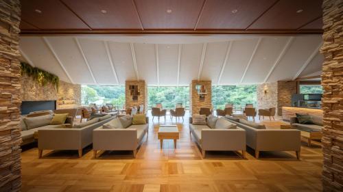 Hotel Shidotaira في هاناماكي: غرفة معيشة كبيرة مع كنب وطاولة