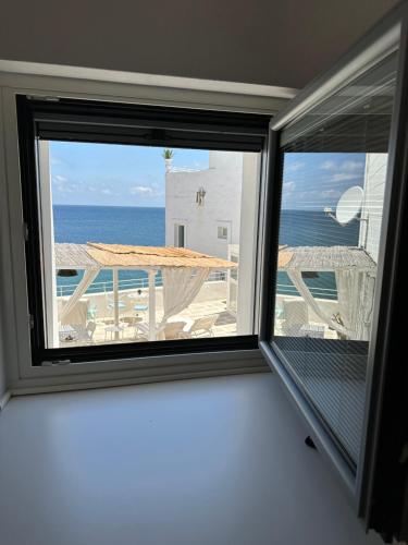 a window in a room with a view of the ocean at AccalmiA in Monopoli