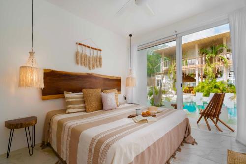 ein Schlafzimmer mit einem großen Bett und einem großen Fenster in der Unterkunft Beautiful Swim-Up Apartment with Private Terrace & Hammoc, Pool & Gym in Tulum