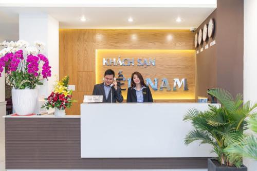 un homme et une femme se tenant derrière un comptoir dans un hall dans l'établissement Yen Nam Hotel Hoang Van Thu, à Hô-Chi-Minh-Ville