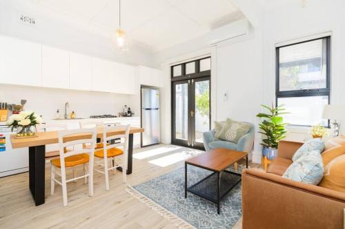 a kitchen and living room with a table and a couch at Crows Nest LemonTree Cozy 3 Bedroom House in Sydney