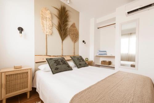 a bedroom with a white bed with two pillows on it at K-NAT by Nuka Homes in Platja de l'Arenal