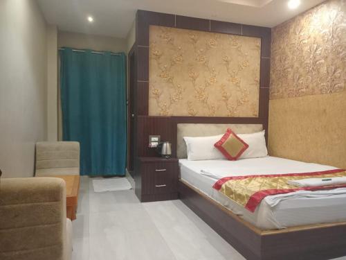 a bedroom with a bed and a chair in a room at The Brahmaputra Hotel in Dhuburi